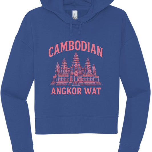 This image features a cobalt blue, cropped-style hoodie with a graphic design centered on the chest. The aesthetic combines a "varsity" feel with travel-themed artwork.
Key Details
Design Elements: * The words "CAMBODIAN" are arched across the top in a light pink, block-style font.
A detailed, salmon-pink illustration of the Angkor Wat temple sits in the center.
The words "ANGKOR WAT" are printed in a straight line beneath the illustration in the same pink font.
Hoodie Style:
It’s a pullover hoodie wit