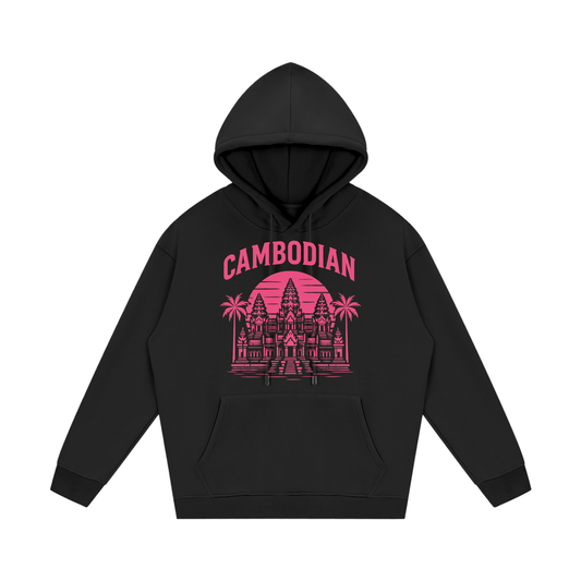 The central artwork uses a bright pink color scheme and includes the following features:

Typography: The word "CAMBODIAN" is printed in a bold, capitalized, sans-serif font that arches over the central image.

Architecture: A detailed illustration of Angkor Wat serves as the centerpiece.

Background: A large, solid circular sun with horizontal line cutouts sits behind the temple, creating a "retro-sunset" or "synthwave" aesthetic.

Nature Details: Two palm trees flank the temple, and horizontal lines at th