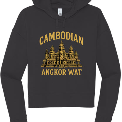 his image features a charcoal black cropped hoodie with a graphic design centered on the chest. The design is printed in a muted gold or mustard yellow color and pays tribute to one of the world's most famous cultural landmarks.

Design Details
Text: The word "CAMBODIAN" is arched across the top in a bold, sans-serif font. Beneath the graphic, the words "ANGKOR WAT" are printed in a straight horizontal line using the same typeface.

Graphic: The center features a detailed illustration of the Angkor Wat temp