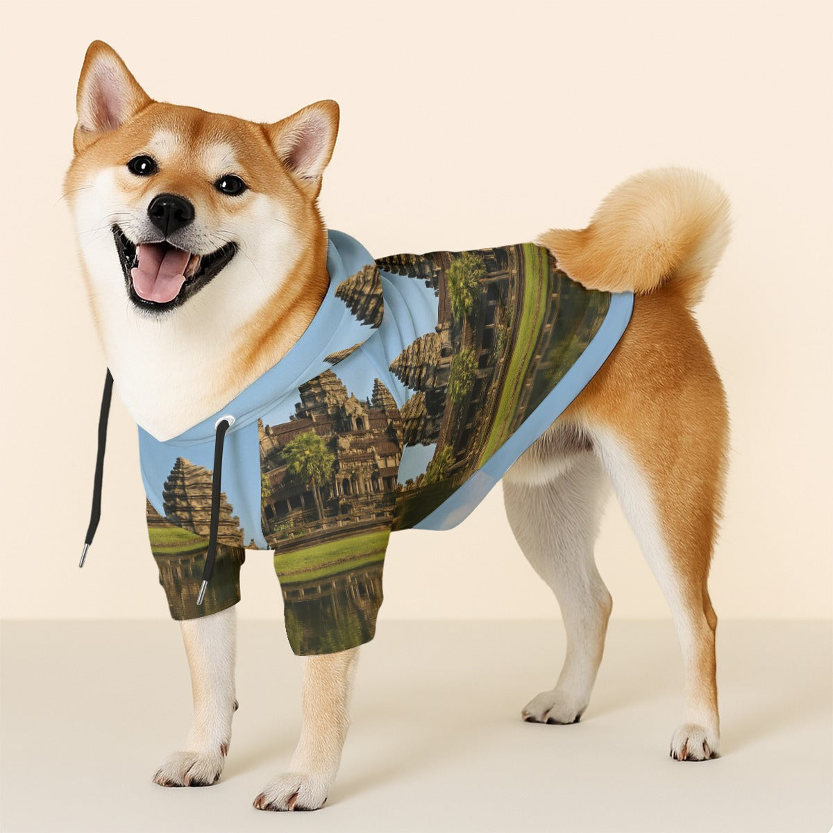Dog wearing a hoodie with Angkor Wat design on a beige background