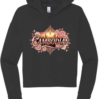 Black "Sunset" Hoodie
The final design combines photographic and illustrative elements for a high-contrast look.

Typography: "CAMBODIAN" is rendered in a glossy, rose-gold 3D font with a dramatic "swoosh" underlining the text.

Central Imagery: In the background, a rectangular window displays a golden silhouette of Angkor Wat against a vibrant orange and yellow sunset.

Ornate Frame: The design is surrounded by a dense cluster of pink and cream roses and topped with traditional Khmer architectural filigree