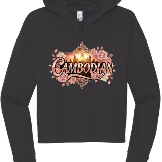 Black "Sunset" Hoodie
The final design combines photographic and illustrative elements for a high-contrast look.

Typography: "CAMBODIAN" is rendered in a glossy, rose-gold 3D font with a dramatic "swoosh" underlining the text.

Central Imagery: In the background, a rectangular window displays a golden silhouette of Angkor Wat against a vibrant orange and yellow sunset.

Ornate Frame: The design is surrounded by a dense cluster of pink and cream roses and topped with traditional Khmer architectural filigree