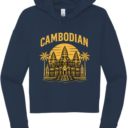 The image shows a navy blue, cropped hoodie featuring a yellow graphic design on the front.

Design and Garment Details
Text: The word "CAMBODIAN" is printed in a bold, arched, yellow serif font at the top of the design.

Illustration: A yellow graphic of Angkor Wat is centered below the text. The temple is depicted against a large, circular sunset background with horizontal lines. Two palm trees frame the temple on either side.

Hoodie Style:

Fit: It is a cropped hoodie with a relaxed, dropped-shoulder sl