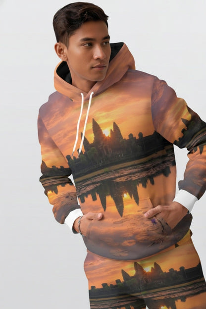 Person wearing a hoodie with a sunset cityscape design on a plain background