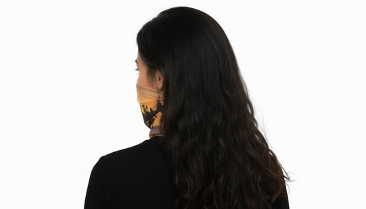Woman wearing a patterned face mask with a scenic design on a white background