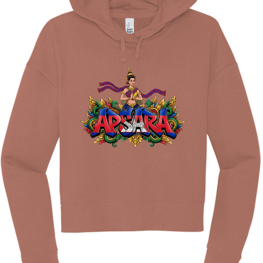 This image shows a terracotta or dusty rose-colored cropped hoodie with a vibrant, illustrative graphic on the chest.

Graphic Design Features
The Text: The word "APSARA" is written in large, bold, block letters. The letters are filled with the colors and imagery of the Cambodian flag, featuring red and blue horizontal bands and the silhouette of Angkor Wat in the center.

The Figure: Above the text is an illustration of an Apsara dancer, a traditional Khmer celestial being. She is depicted in 