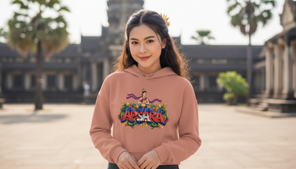 Woman wearing a pink hoodie with colorful text in front of Angkor Wat.