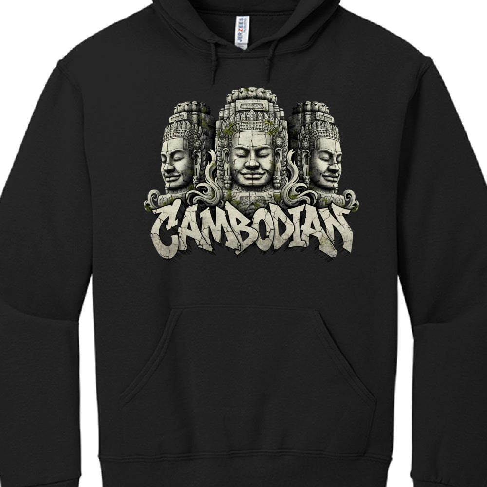 Central Imagery: Three stone-carved faces, reminiscent of the famous Bayon Temple sculptures at Angkor Thom in Cambodia. The faces have serene expressions with closed eyes, detailed traditional headwear, and hints of green moss/vegetation growing in the crevices to give them an "ancient ruin" aesthetic.

Typography: Below the faces, the word "CAMBODIAN" is written in a bold, stylized graffiti font. The letters have a cracked, stone-like texture that matches the sculptures above, creating a cohesive visual t