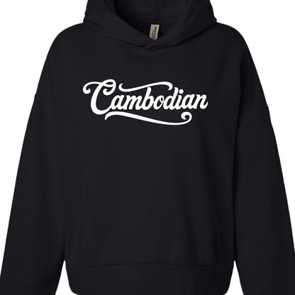 Typography: The word "Cambodian" is printed across the chest in a thick, white cursive script. The font features elegant swashes, including a long underline extending from the "C" and a decorative tail on the final "n".

Apparel: A black pullover hoodie with a slightly different cut than the first, featuring a more pronounced waistband and a neck tag labeled "INDEPENDENT".
