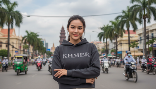 Woman wearing a hoodie with 'KHMER' text on a busy street.
