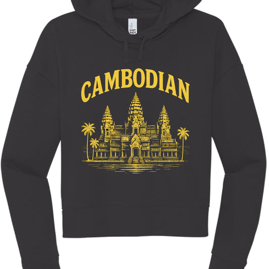 This image showcases a black cropped hoodie with a graphic design centered on the chest, similar in style to the previous version but with a different color scheme.

Design Elements
Text: The word "CAMBODIAN" is printed in a bold, arched, serif font across the top.

Graphic: Below the text is a detailed illustration of Angkor Wat, featuring its characteristic three towers and surrounding palm trees.

Colorway: This version uses a bright yellow (gold) ink for the text and illustration, creating a sharp contr