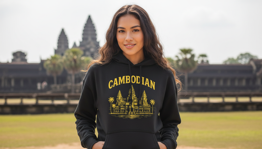 Woman wearing a black hoodie with 'Cambodian' text and Angkor Wat design, standing in front of Angkor Wat.