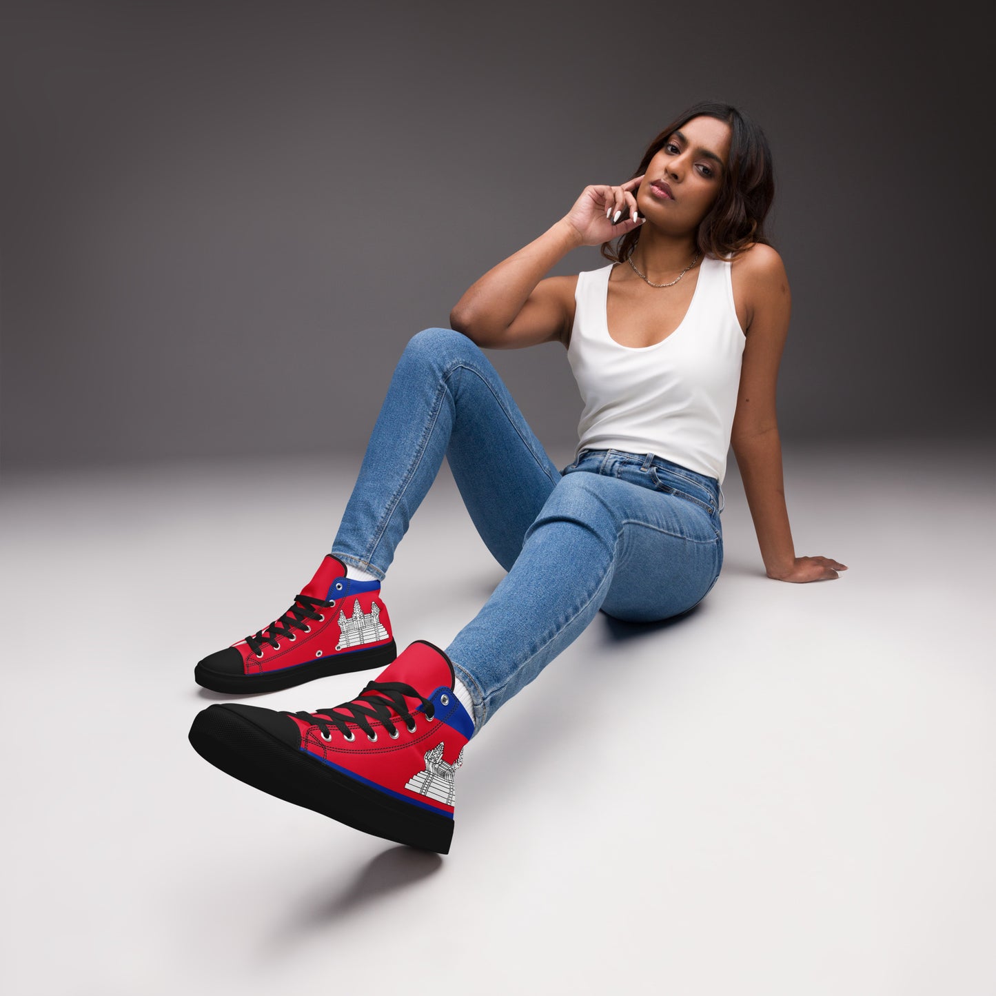 Woman wearing red high-top sneakers with a gray background