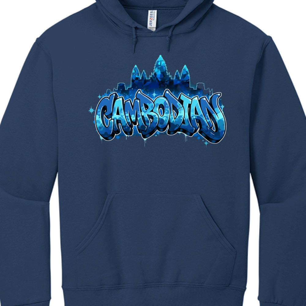 The central graphic utilizes a monochromatic blue color scheme with white accents to create depth and contrast:

Typography: The word "CAMBODIAN" is written in a large, bubbly graffiti font. The letters feature a blue camouflage or water-like pattern, highlighted with white outlines to make them pop against the dark fabric.

Iconography: Silhouetted behind the text is the unmistakable outline of Angkor Wat, the famous Cambodian temple complex. The towers are rendered in various shades of blue, blending the 