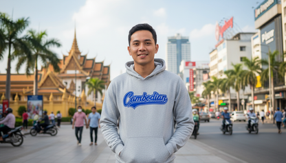 Person wearing a gray hoodie with 'Cambodian' text on a city street.