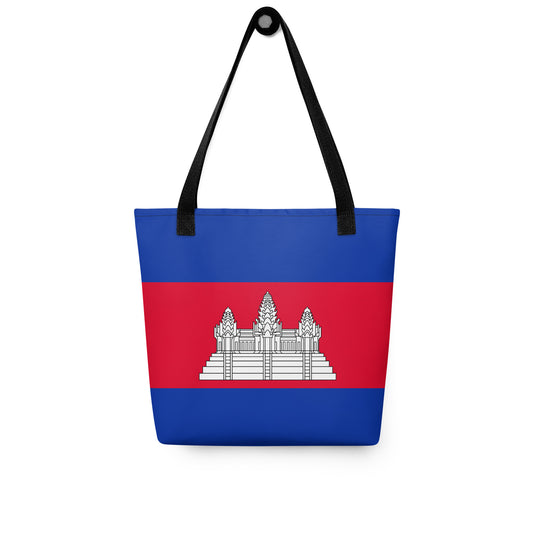 Cambodian Flag Tote Bag
This image is a digital mockup of a tote bag featuring the design of the Cambodian national flag.

Design: The bag is divided into three horizontal stripes: a wide red band in the center sandwiched between two blue bands at the top and bottom.

Symbolism: The center of the red band features the white, three-towered silhouette of Angkor Wat, the primary national symbol of Cambodia.

Hardware: The bag is equipped with two sturdy, black fabric shoulder straps attached to the top rim.