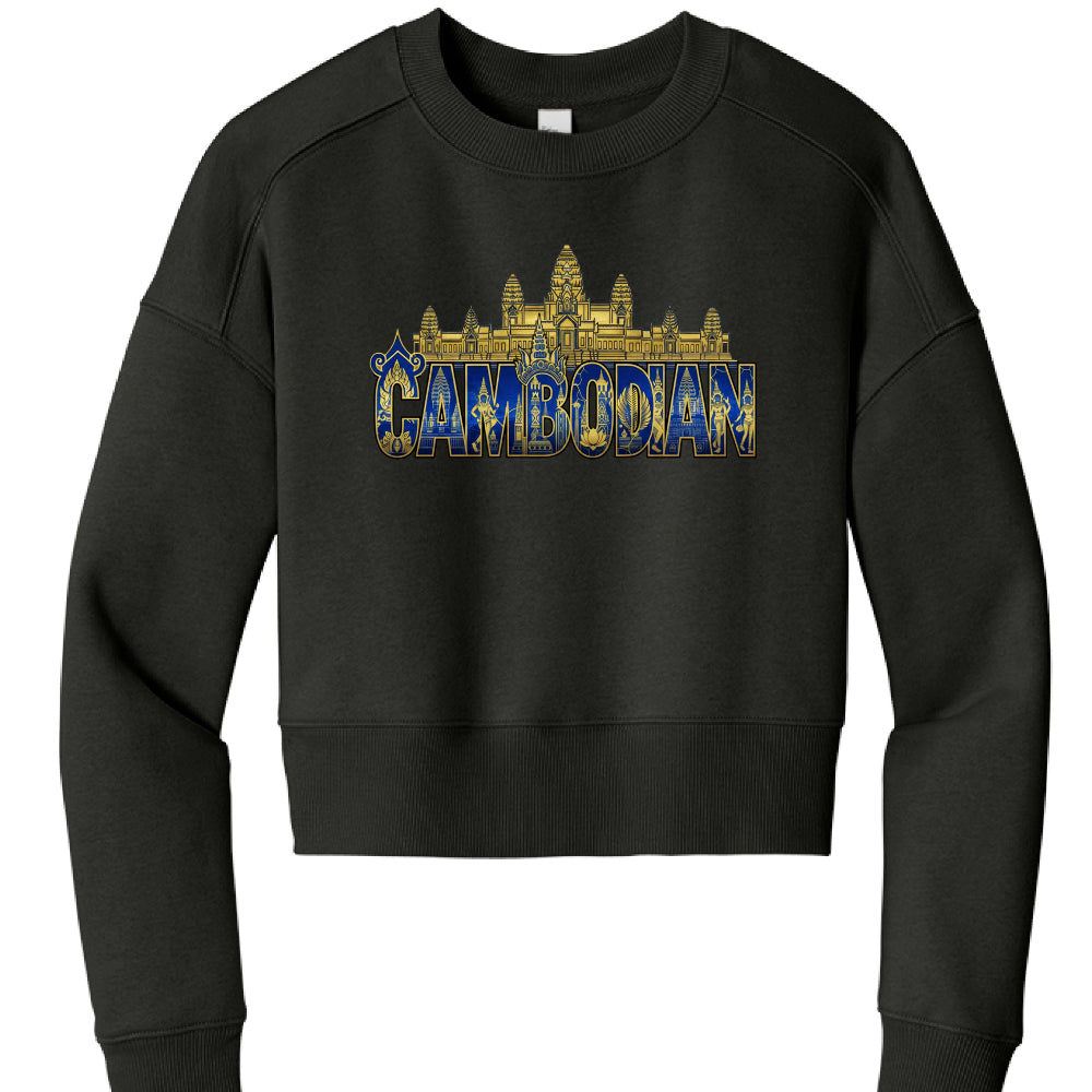 The image shows a black cropped sweatshirt with an ornate graphic design centered on the chest.

Garment Details
Type: Long-sleeved crewneck sweatshirt with a cropped fit.

Color: Solid black.

Construction: Features drop-shoulder sleeves, ribbed cuffs, and a thick ribbed hem at the waist.

Graphic Design
The artwork uses a regal gold and blue color palette and includes several cultural elements:

Top Layer: A gold silhouette of the Angkor Wat temple complex sits above the text.

Typography: The word "CAMBO
