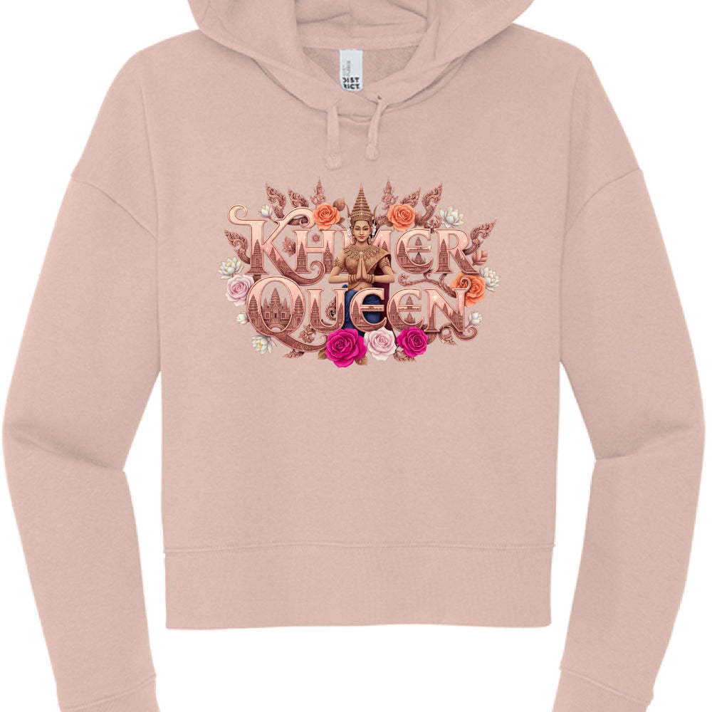 This image features a dusty rose or blush-colored cropped hoodie showcasing a highly detailed, ornate graphic centered on the chest. The design celebrates Cambodian heritage with a royal and floral theme.

Design Elements
Typography: The words "KHMER QUEEN" are displayed in a bold, metallic rose-gold font with intricate, carved-style detailing. The letter "Q" in "Queen" features a silhouette of the Angkor Wat temple towers within its center.

Central Figure: A woman dressed in traditional Cambodian Apsara a