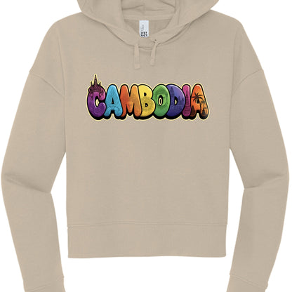 This hoodie presents a cleaner, pop-art style design using vibrant colors.

The Garment: A light sand or tan-colored cropped hoodie of the same cut and style as the first.

The Design: The word "CAMBODIA" is written in large, rounded bubble letters, with each letter featuring a different color and a unique internal illustration.

Letter Details:

C: Purple with a traditional Apsara headdress silhouette.

A: Light blue with a temple gate design.

M: Orange with a serene face, likely a Bayon-style Buddha.

B: