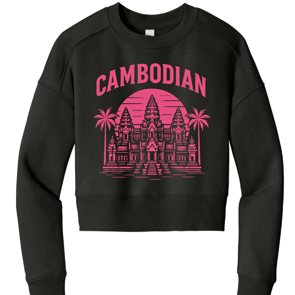 This image features a black, long-sleeved cropped sweatshirt with a vibrant graphic design centered on the chest.

Design Details
The graphic is rendered in a bright pink (magenta) ink and follows a retro, synthwave-inspired aesthetic:

Typography: The word "CAMBODIAN" is arched across the top in a bold, sans-serif block font.

Illustration: The centerpiece is a detailed, stylized illustration of Angkor Wat, the famous temple complex in Cambodia.

Background Elements: * A large, circular "sunset" with horiz