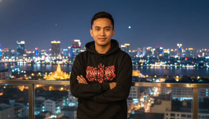 Person wearing a black hoodie with red graphics against a city skyline at night.