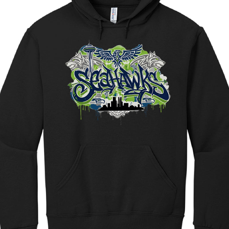 Black Hoodie
This hoodie presents a more "street" aesthetic with aggressive wildlife imagery:

Typography: The "SEAHAWKS" font here is more rounded and fluid, featuring a heavy blue-to-green gradient and dripping paint effects.

Animals: The design is flanked by two snarling wolf heads in grey and white. Above the text is a stylized bird with spread wings, different from the traditional team logo.

Background: The Space Needle is positioned to the left, and a solid black skyline silhouette sits at the base 