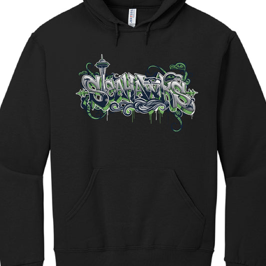 Navy Blue Hoodie: This design emphasizes the cultural heritage of the Pacific Northwest by featuring a large seahawk rendered in a Coast Salish or Pacific Northwest Indigenous (Formline) art style. Behind the "SEAHAWKS" graffiti-style text, a faint silhouette of the Seattle skyline, including the Space Needle, is visible alongside evergreen trees and lightning bolts.

Heather Grey Hoodie: This version highlights Seattle’s urban and maritime identity with a prominent black silhouette of the skyline that incl