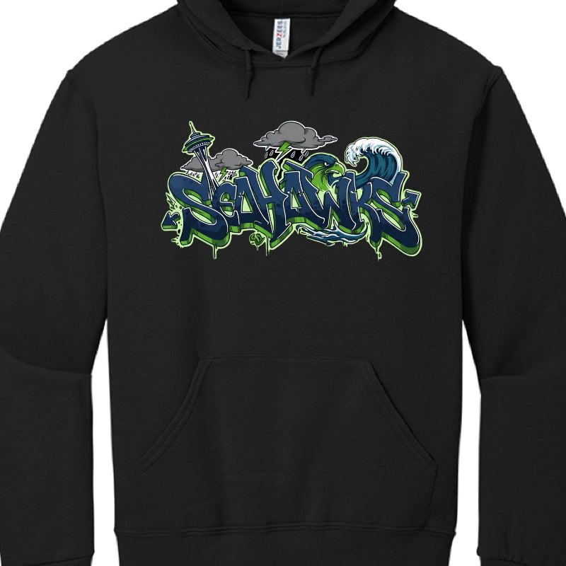 This image shows a black hooded sweatshirt featuring a large, stylized graphic on the chest. The design is a graffiti-inspired tribute to the Seattle Seahawks.

Graphic Components
The central text reads "SEAHAWKS" in a bold, 3D graffiti font. The letters are primarily navy blue with bright action green outlines and highlights.

Seattle Landmarks: A grey and green Space Needle is visible on the left side, behind the first few letters.

Weather Elements: Above the text, there are dark grey storm clouds with g