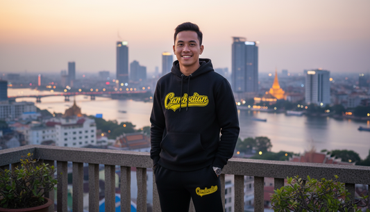 Person wearing a black hoodie with yellow text, standing in front of a city skyline at dusk.