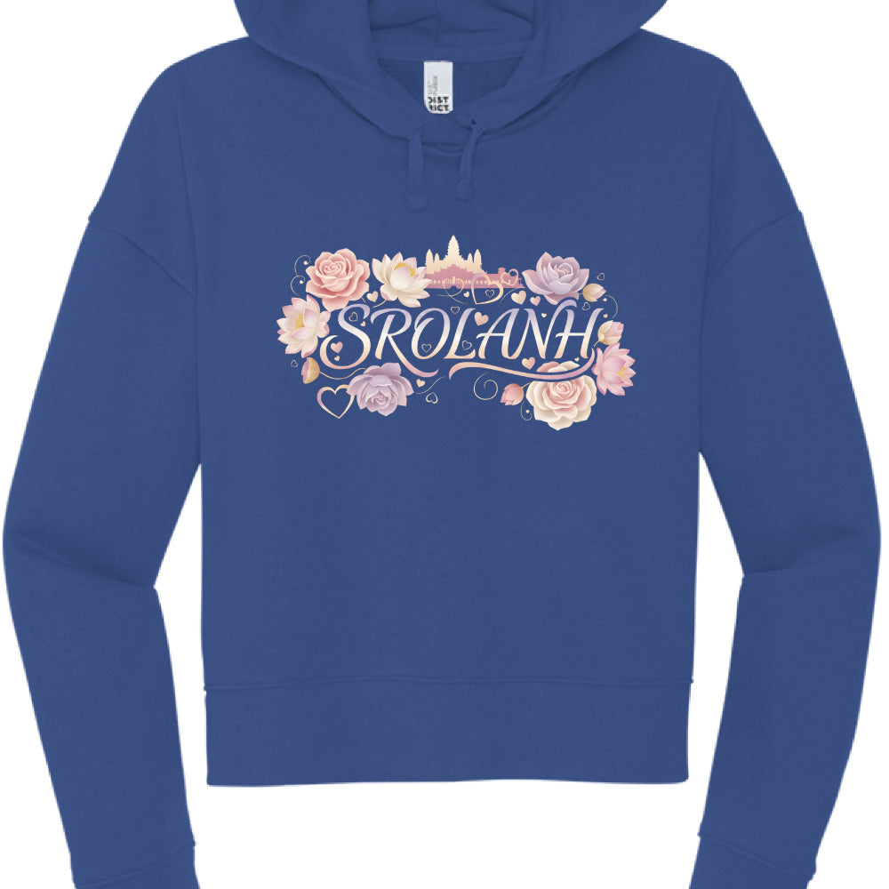 "Srolanh" (Black & Royal Blue Hoodies): These cropped hoodies feature the word "SROLANH" (Khmer for "love") in a delicate, iridescent script.

The designs are framed by an assortment of pink roses, lotuses, and small floating heart icons.

A soft gold silhouette of Angkor Wat sits behind the text on the black hoodie, while the blue hoodie features a similar floral and temple backdrop.