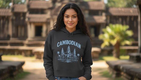 Woman wearing a hoodie with 'Cambodian' and Angkor Wat design in front of a temple.