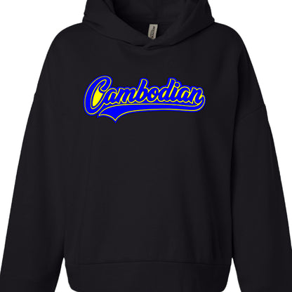 Apparel Type: A standard black pullover hoodie with a front kangaroo pocket and an adjustable hood.

Graphic Design: The word "Cambodian" is written in a stylized, cursive script.

Color Scheme: The text is bright yellow with a thick royal blue outline. A blue "swoosh" or underline detail extends from the bottom of the first letter, giving it a classic athletic or "varsity" aesthetic.

Brand Tag: A small white tag is visible on the inside of the collar, appearing to be from the brand "Independent Trading Co