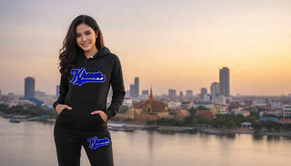 Woman wearing a black hoodie with 'Klaver' logo in front of a city skyline at sunset.
